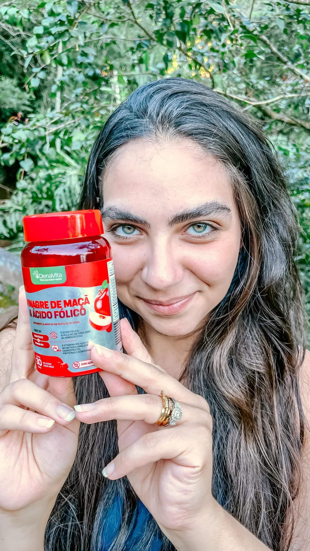 Rebeca Campano segurando o pote de gummy de vinagre de maçã da Denavita